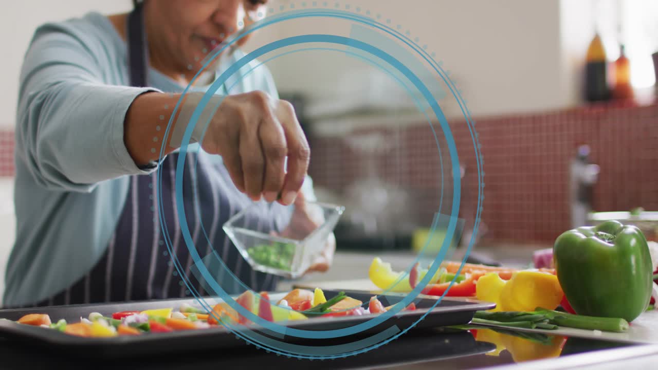 Senior woman pinching herbs and seasoning veggies on counter, with pulsing blue circle for coverage
