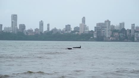 skyline buildings of mumbai with sea waves on a cloudy monsoon day