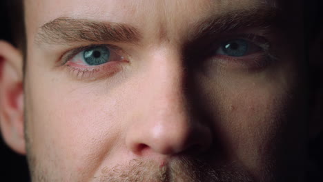 macro portrait of young man opening his closed eyes.eyes looking at camera.