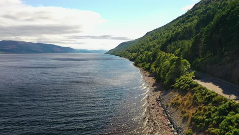 Luftaufnahme-Entlang-Der-Küste-Von-Loch-Ness-Mit-üppigem-Grünem-Wald,-Schottisches-Hochland,-Schottland