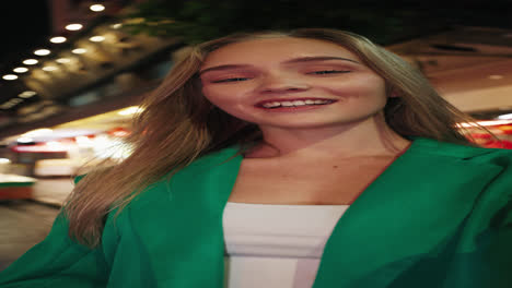 happy woman in a green jacket at night