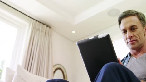 hombre maduro usando una tableta digital en casa