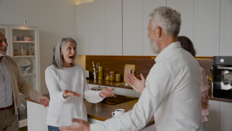 two older women hugging two older friends in the kitchen 1