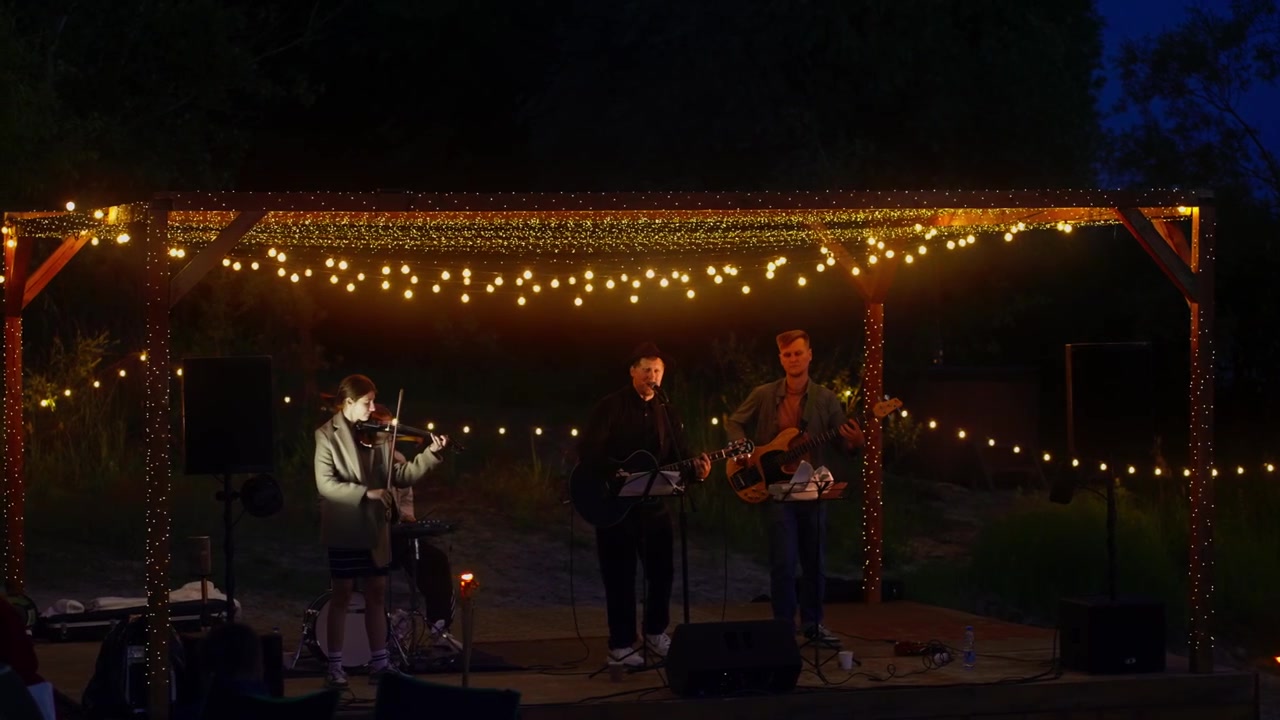 Small Musical Band Performing Live on Outdoor Stage at Night