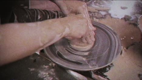 a potter teaches a woman to make clay dishes. a man takes a woman's hands. vintage effect.