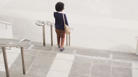 African-american-businesswoman-walking-and-talking-on-smartphone