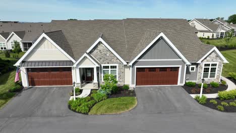 drone view tilting up of several townhomes and an apartment complex in a private community on a clear summer day