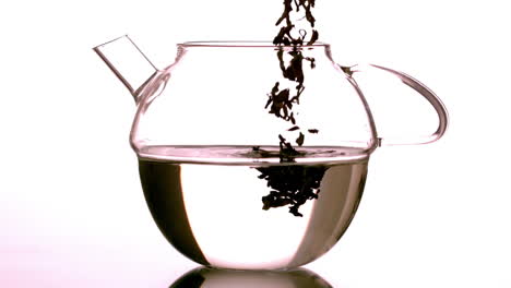 Loose-tea-falling-into-glass-teapot-