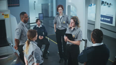airport security personnel discussing at security checkpoint