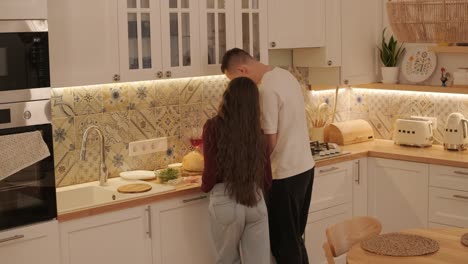 una pareja enamorada haciendo un sándwich en la cocina de la sala de estar
