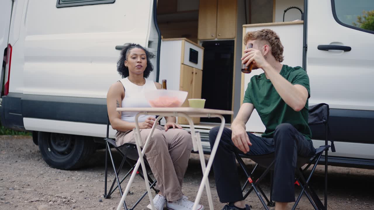 People and a dog eating near a van