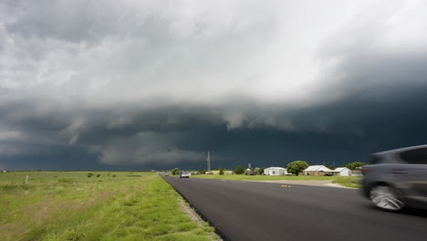 dark threatening storm clouds approaching small town country road