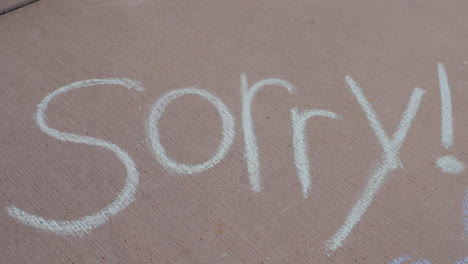 Closeup-of-the-work-Sorry-with-an-exclamation-point-written-in-sidewalk-chalk