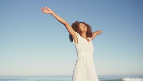 mujer afroamericana disfrutando del aire fresco de la playa