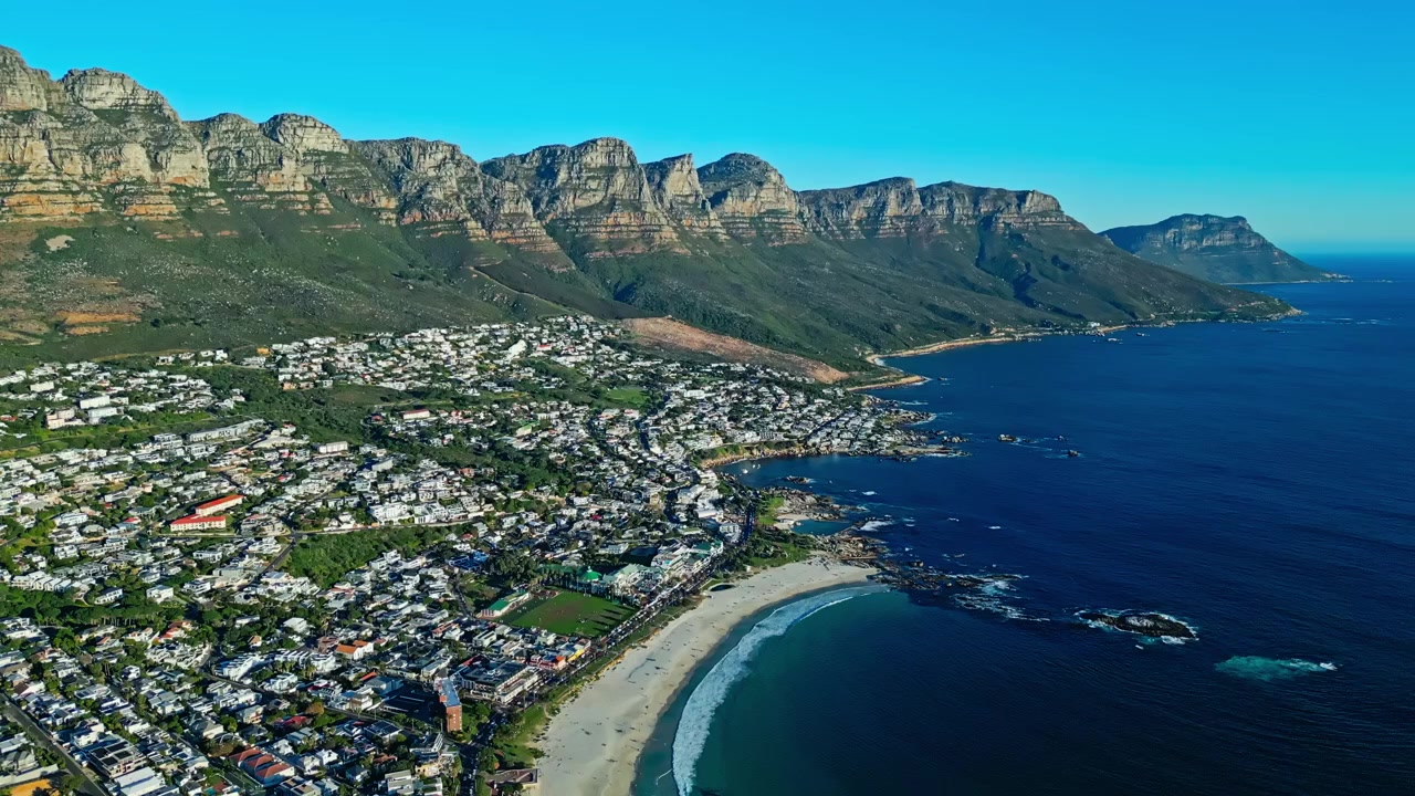 Güney Afrika'daki Camps Bay ve Cape Town'ın, Atlantik kıyı şeridinin üzerinde yükselen Masa Dağı ve ünlü şehir metropol manzarasıyla havadan görünümü.