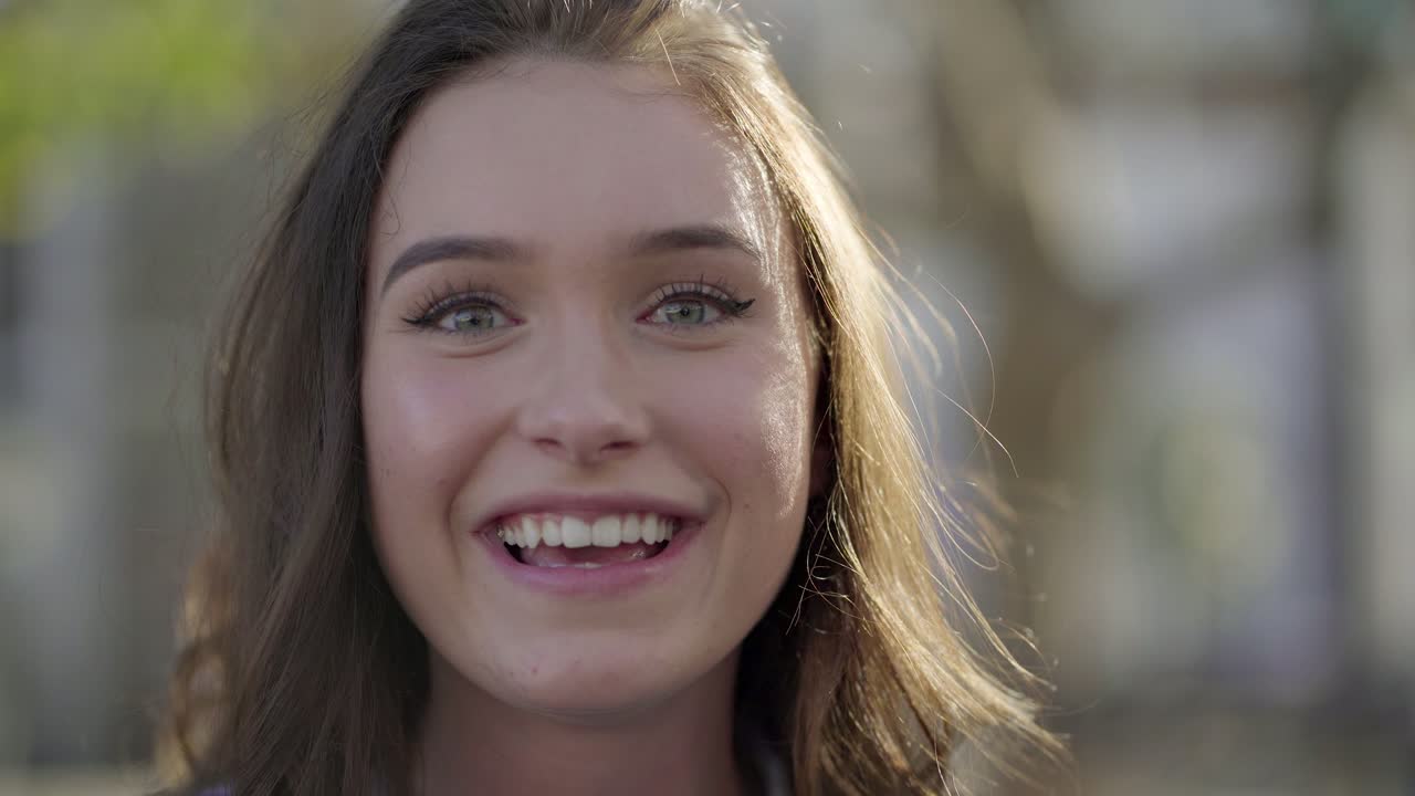 mujer en el parque teniendo video chat por teléfono, comportándose emocionalmente