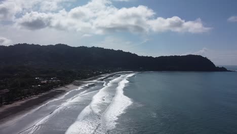 Beautiful-drone-shot-flying-over-the-black-sand-beach-in-Jacó,-Costa-Rica