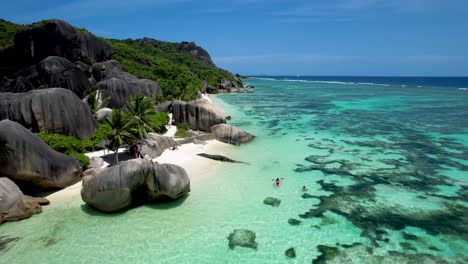 kayaking off the coast of anse source d'argent beach on la digue island in the seychelles in clear bottom boat