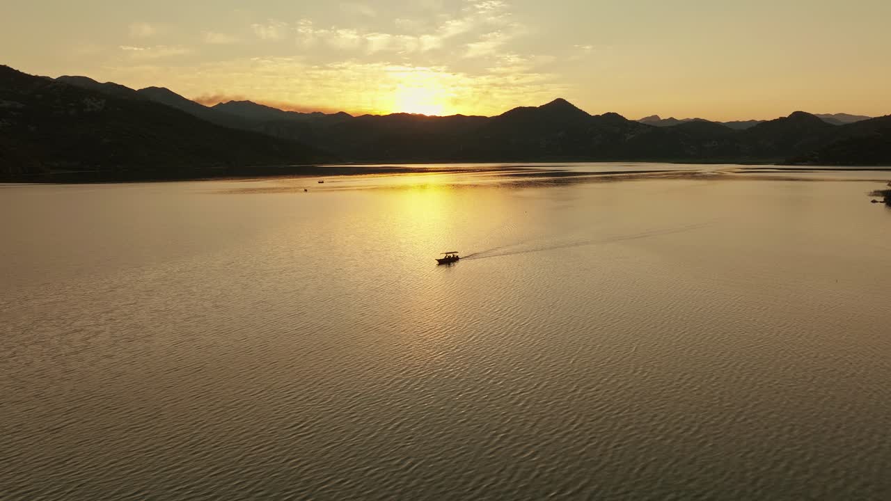 Golden hour over Skadar Lake, Montenegro with a boat gliding across the water