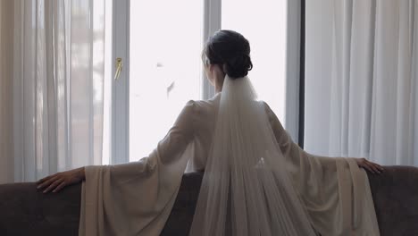 Bride-in-boudoir-dress-near-window,-wedding-morning-preparations,-woman-in-night-gown-and-veil