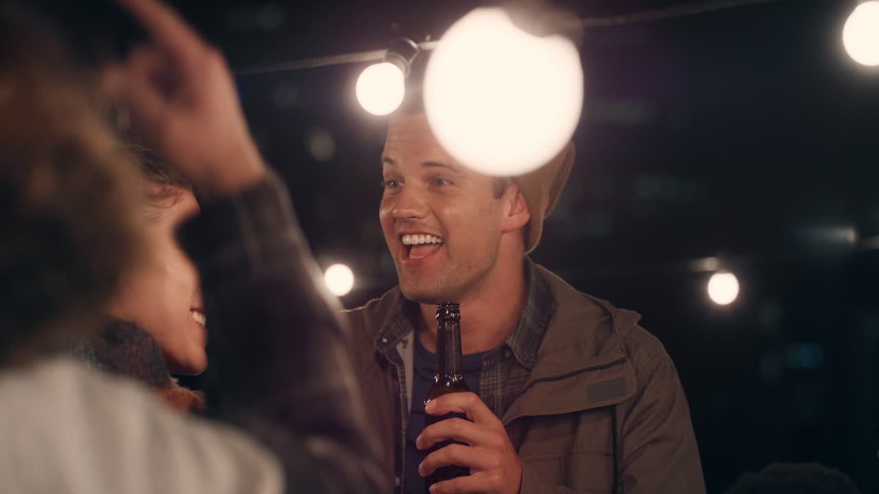 multi ethnic group of friends having fun dancing to music on rooftop at night enjoying celebration party
