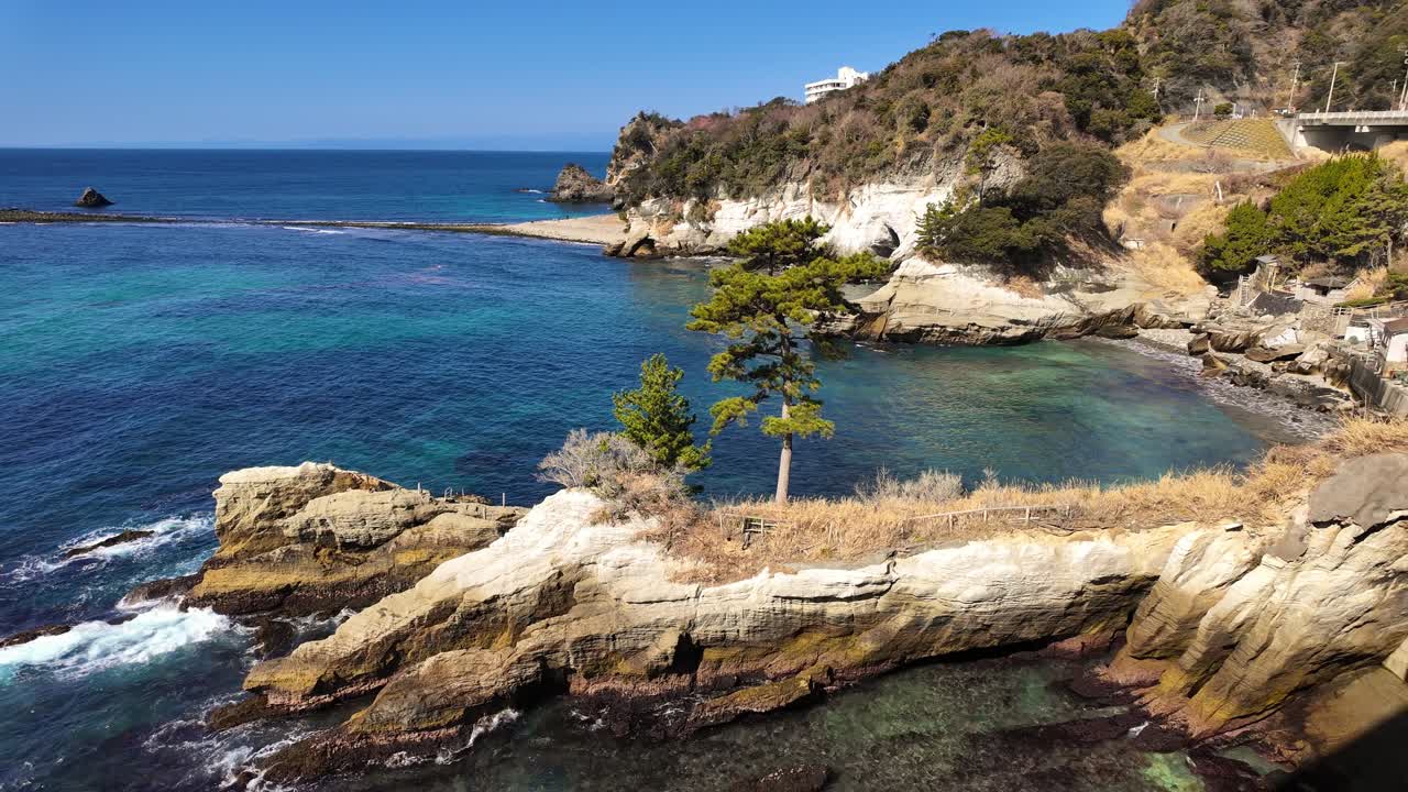 Una panoramica mozzafiato che mostra le splendide acque turchesi di Dogashima, Giappone. La ripresa cattura un'isola rocciosa e il famoso tombolo.