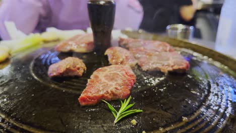 Flipping-steaks-cooked-on-traditional-Korean-grill