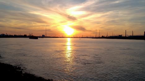 silhouette cargo ships at the international port of antwerp belgium at sundown