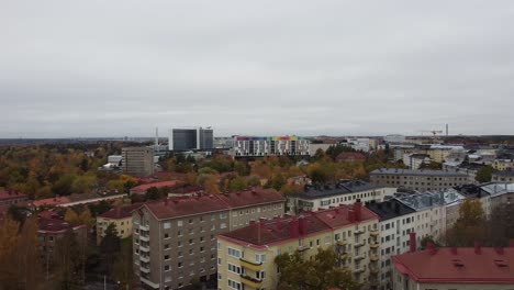 aerial pan shot of poor district in helsinki with high rising apartments blocks beside river