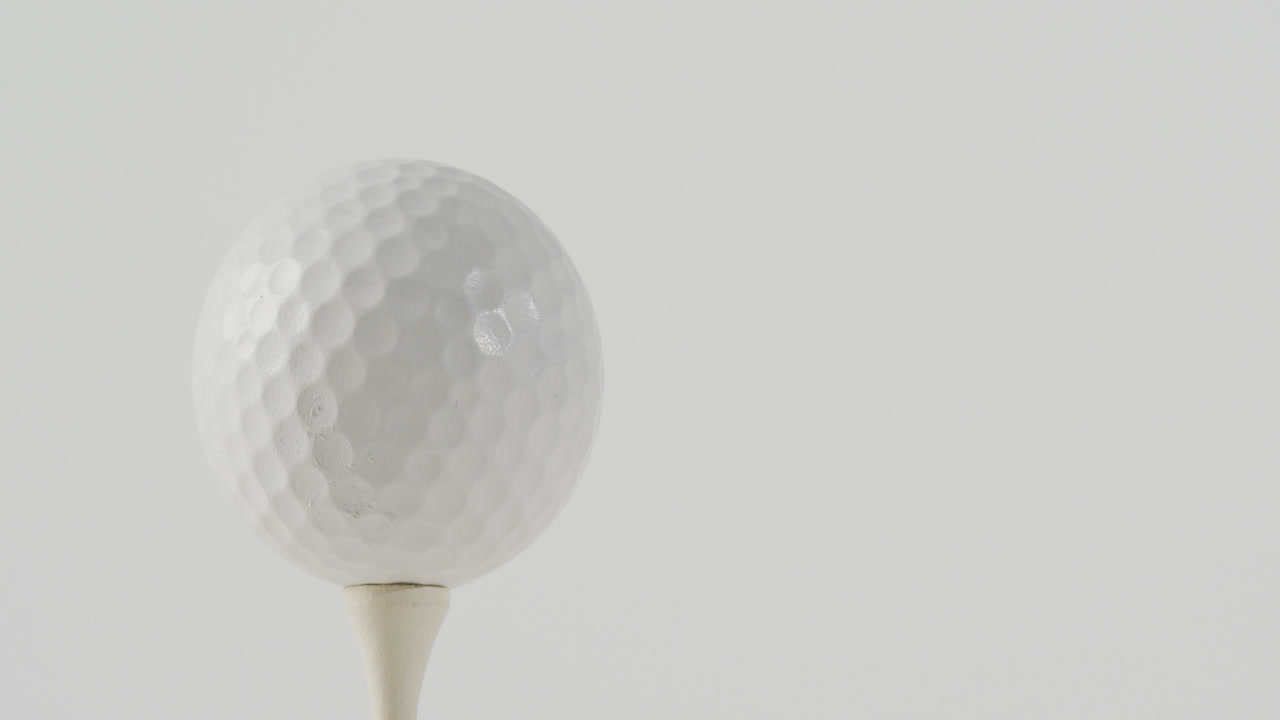 ⁇ 색 배경 에 있는 골프 티 와 공 의 클로즈업, 복사 공간, 느린 동작