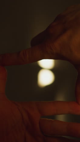 pov de manos formando un marco cinematográfico, capturando sombras en la pared a través de la luz del sol, filmado con una cámara de mano