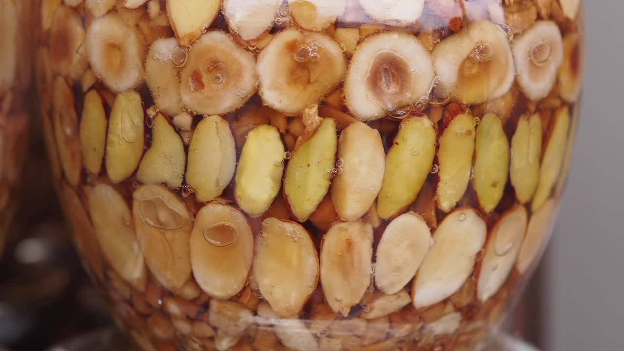 Primo piano di frutta secca assortita conservata nel miele in un barattolo di vetro