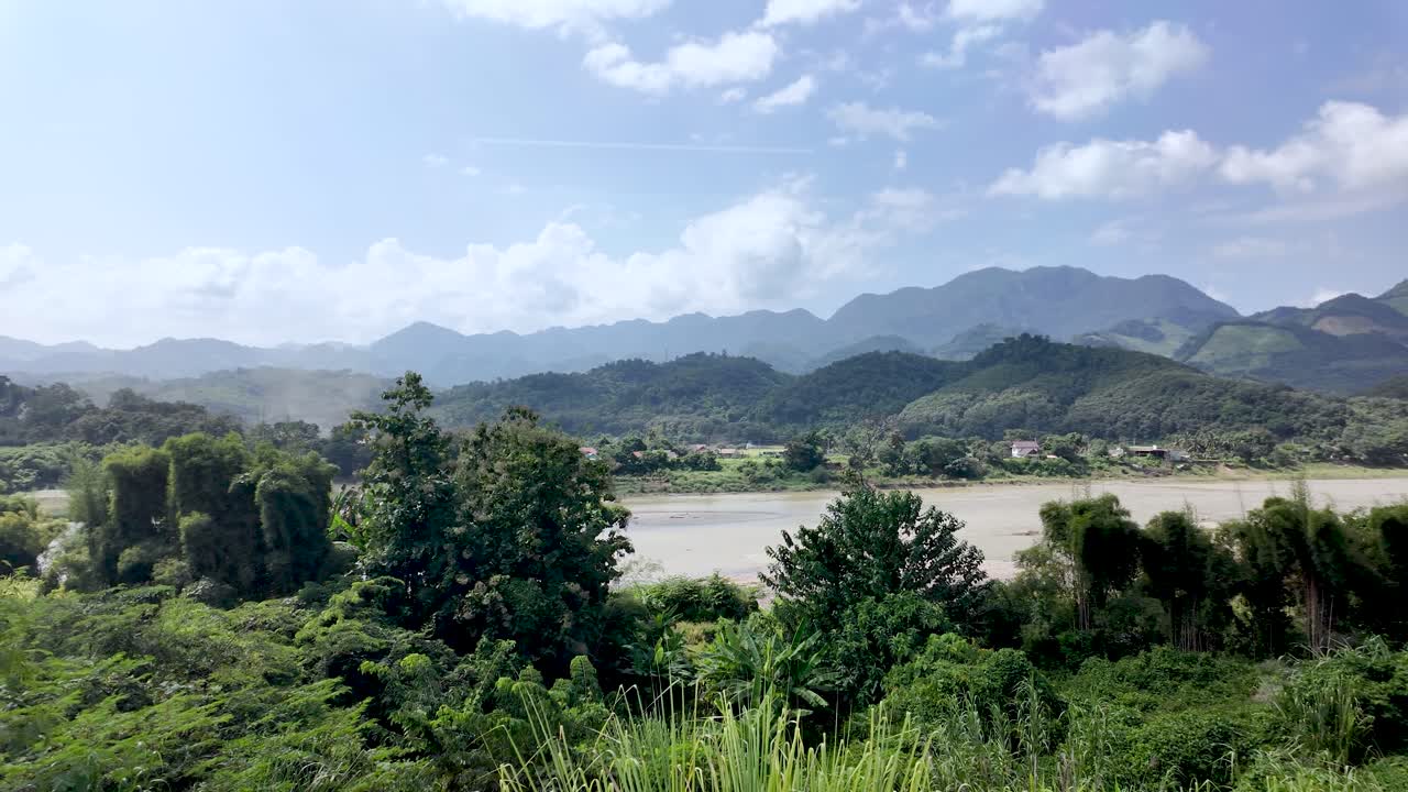 Vista panoramica di Vang Vieng, Laos, con montagne, un fiume e una vegetazione lussureggiante sotto un cielo limpido