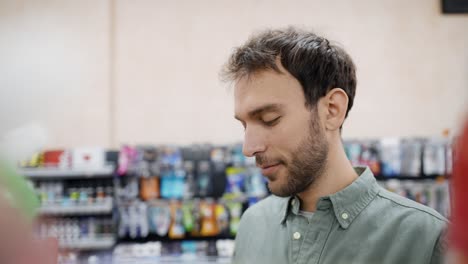 man taking package footage from the shelf. doing shoping in supermarket