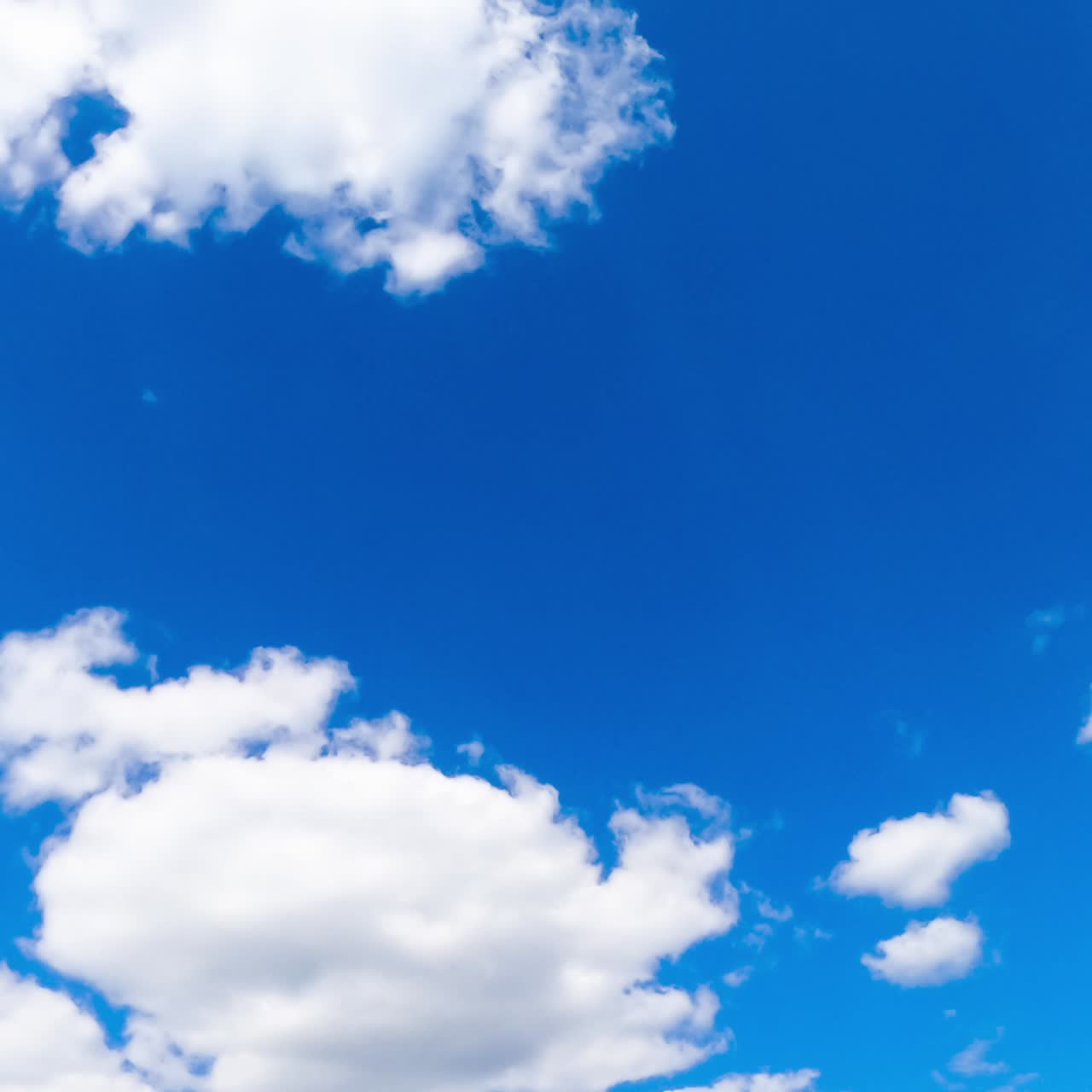 Magnifico cielo estivo blu con poche nuvole bianche che navigano. Visuale dal basso. Timelapse