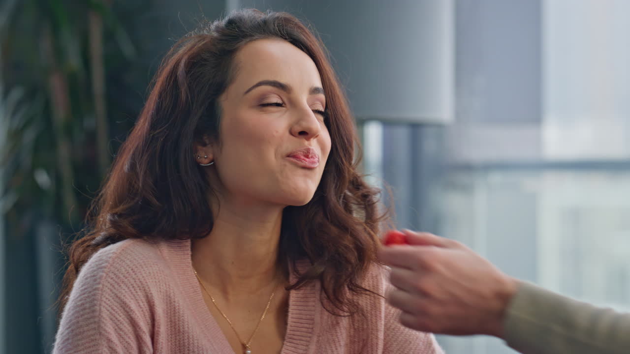 hombre dando fresa mujer alimentando a su esposa en el desayuno de primer plano.