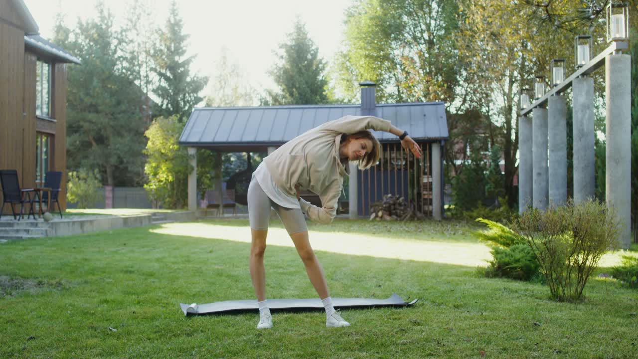 mujer estirándose al aire libre en el patio trasero