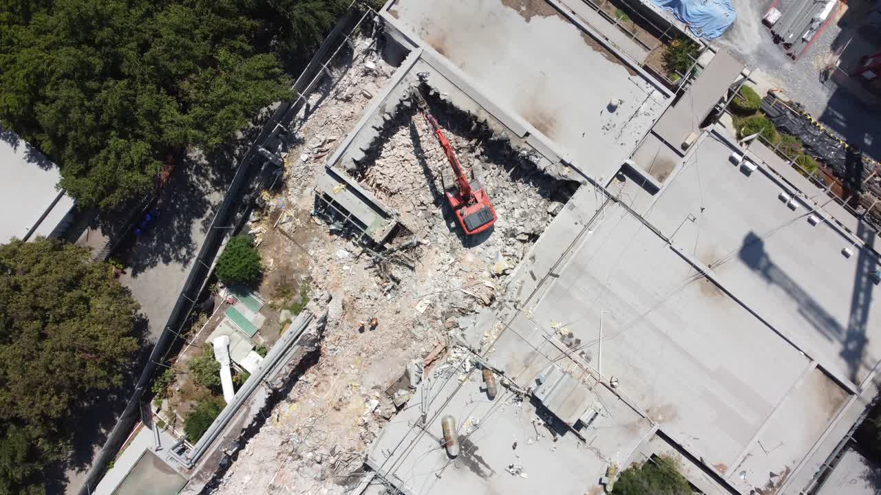 un excavador tirando del techo de un edificio