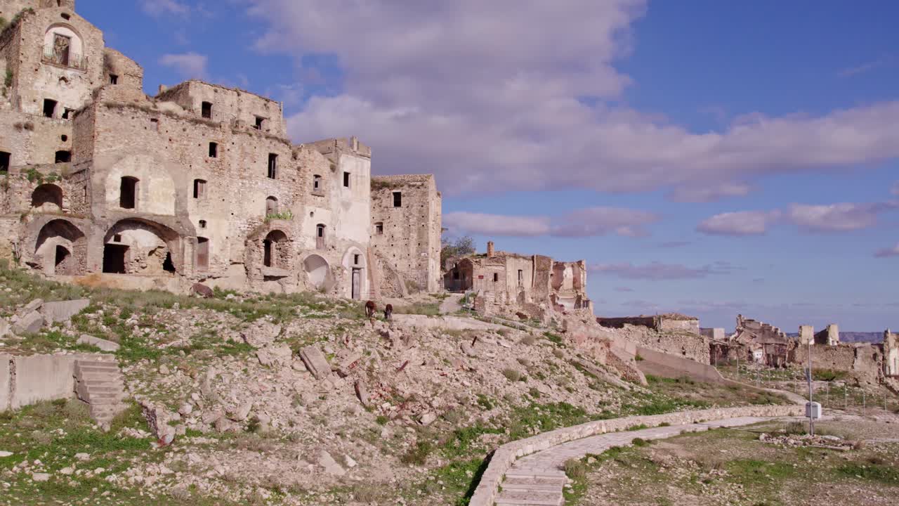 Città fantasma desolata con asino sulla collina, Craco, Basilicata, Italia