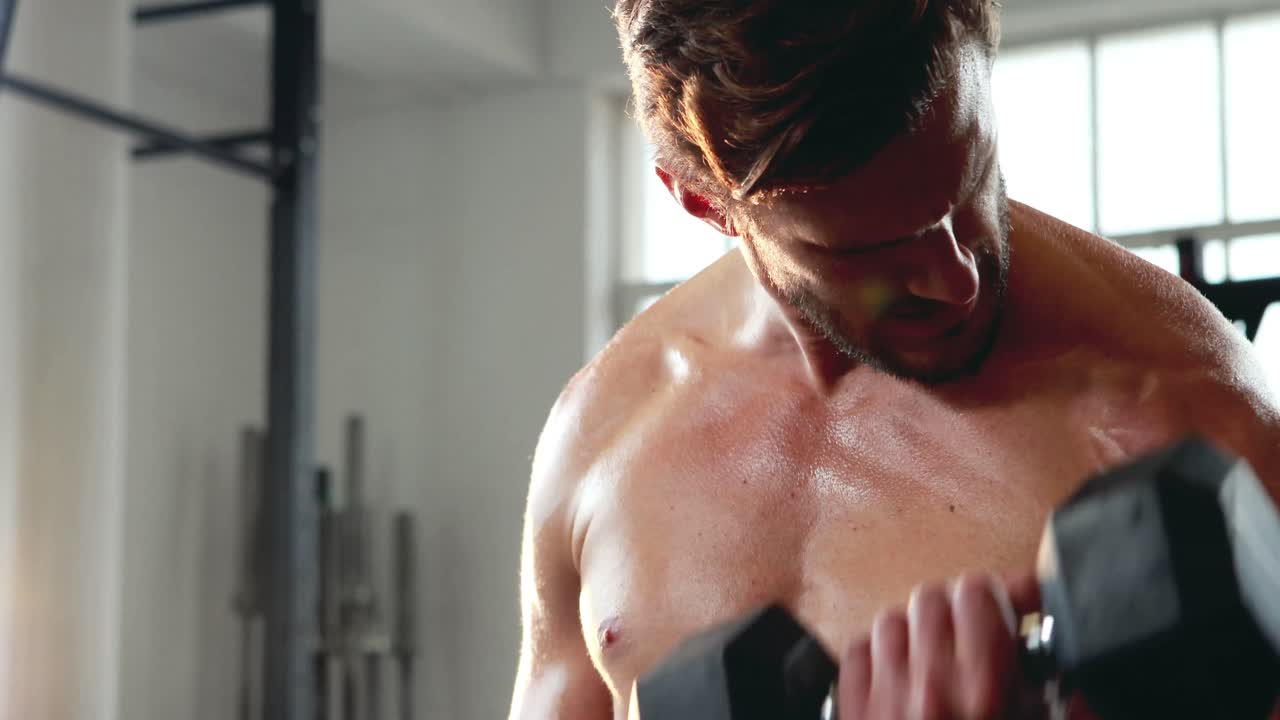 무거운 검은색 덤벨을 들어 올리는  ⁇ 한 남자