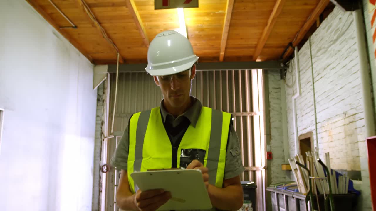 ingeniero masculino que mantiene las existencias en el taller 4k