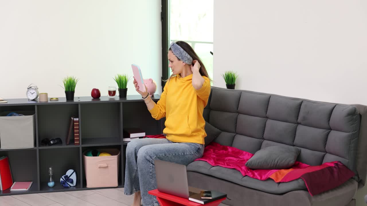Woman sitting on sofa with laptop
