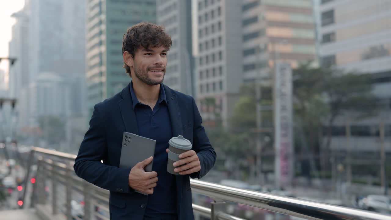 Selvsikker forretningsmand, der går i byen med tablet og kaffe