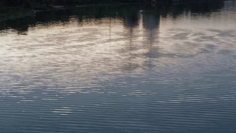 las ondas tranquilas del río que reflejan el paisaje urbano abstracto disparado por un dron. textura del agua azul