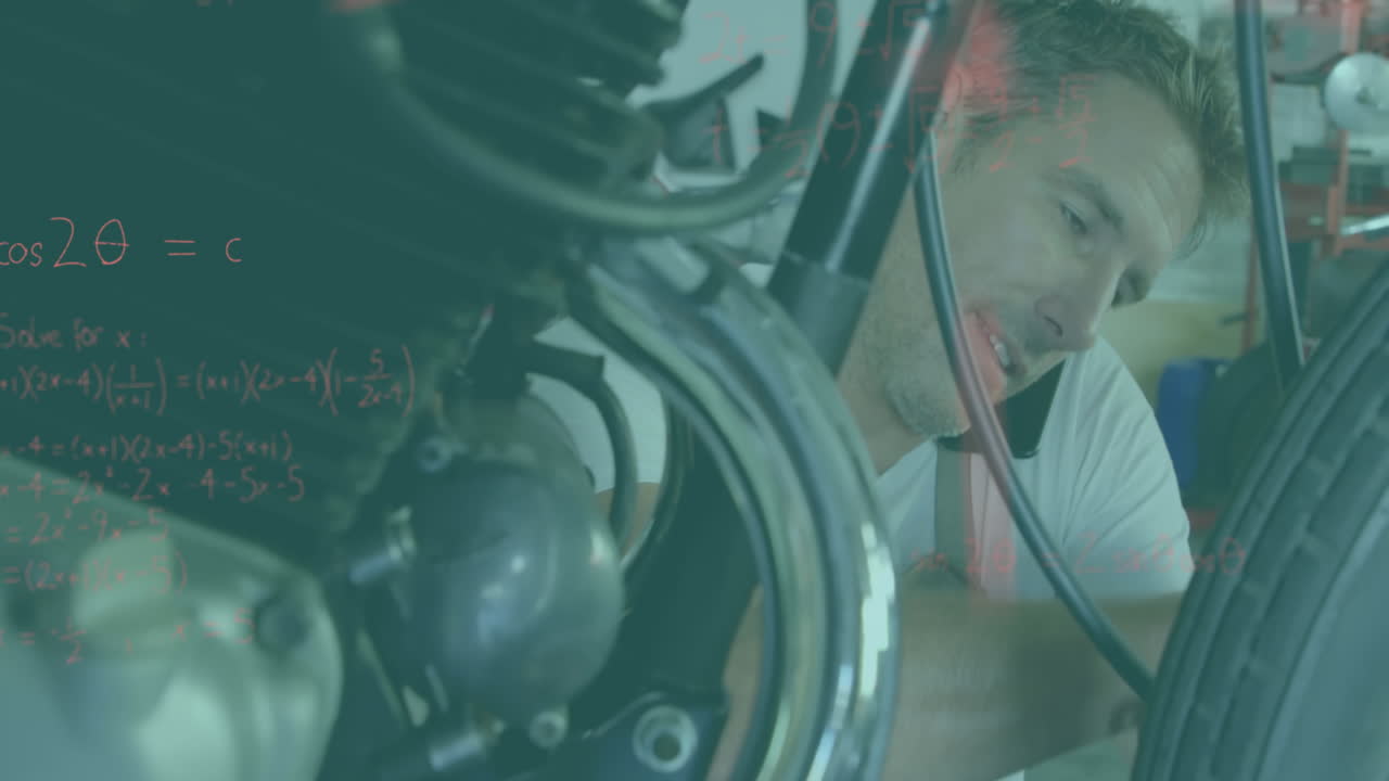 모터사이클을 수리하는 남자와 전화로 수학 방정식을 풀고 있습니다.