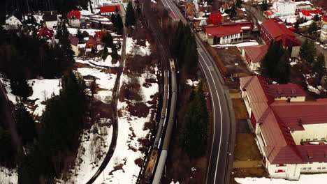 Luftdrohnenaufnahme-Rumänischer-Züge-Im-Predeal-Dorf,-Rumänien-Im-Schnee-Im-Winter