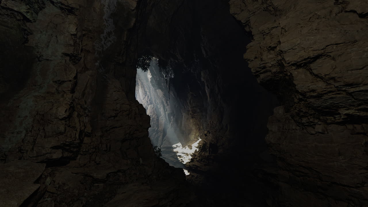 Light streaming through a cavern opening illuminates a rocky interior