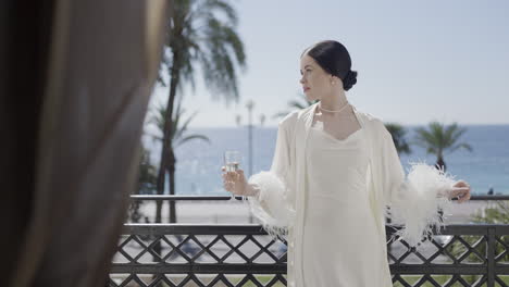 elegant woman with champagne on a balcony