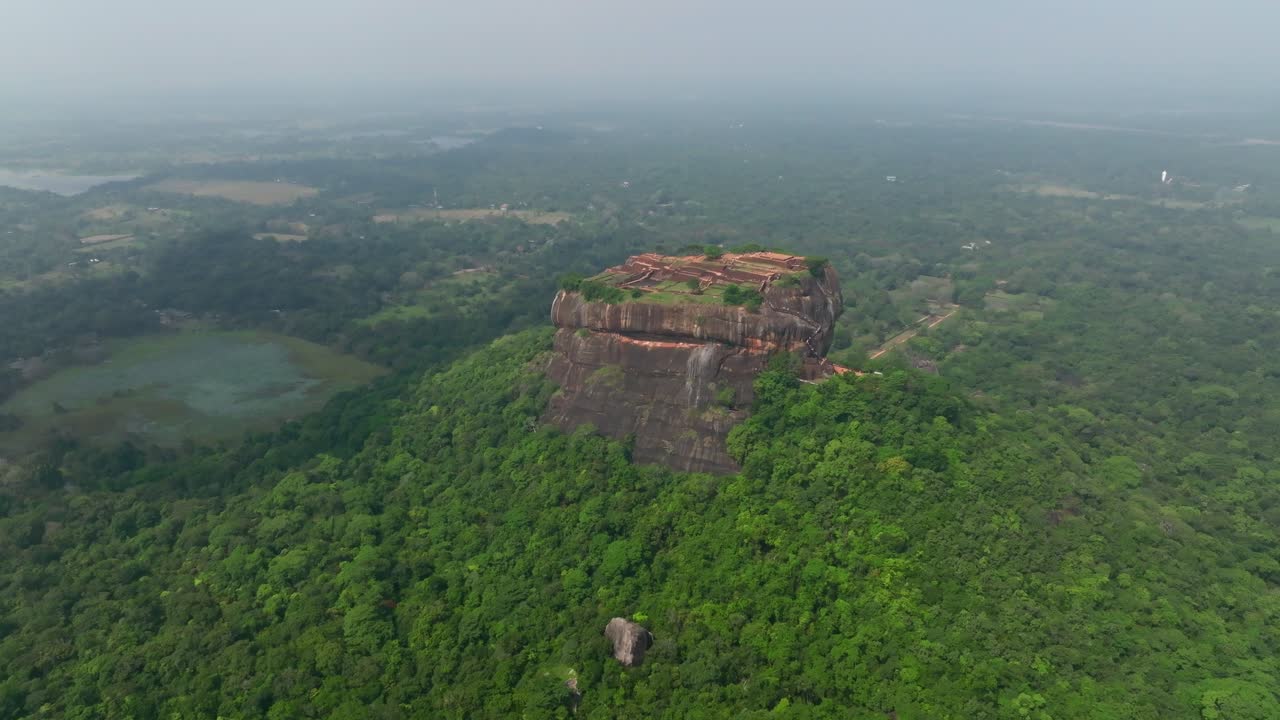Sri Lanka-landskap med utsikt over Sigiriya Rock Fortress over en lotusinnsjø og grønn våtmark under en klar himmel
