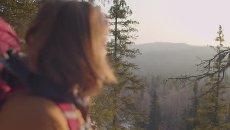 male tourist enjoying view of winter forest from mountain